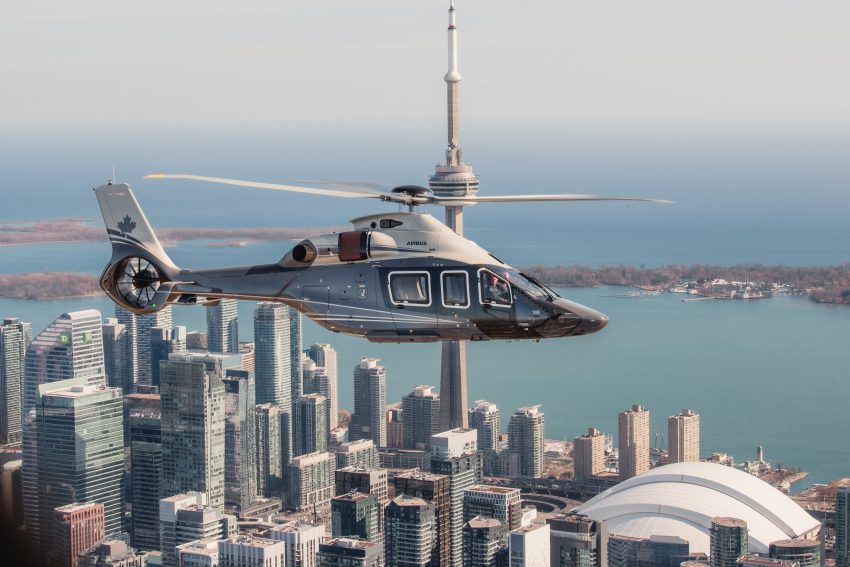Canadian ACH160 helicopter flying near the CN tower over the city of Toronto