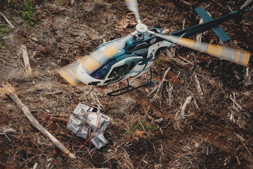 Airbus H125 carrying a bag of seedlings to a tree planting block